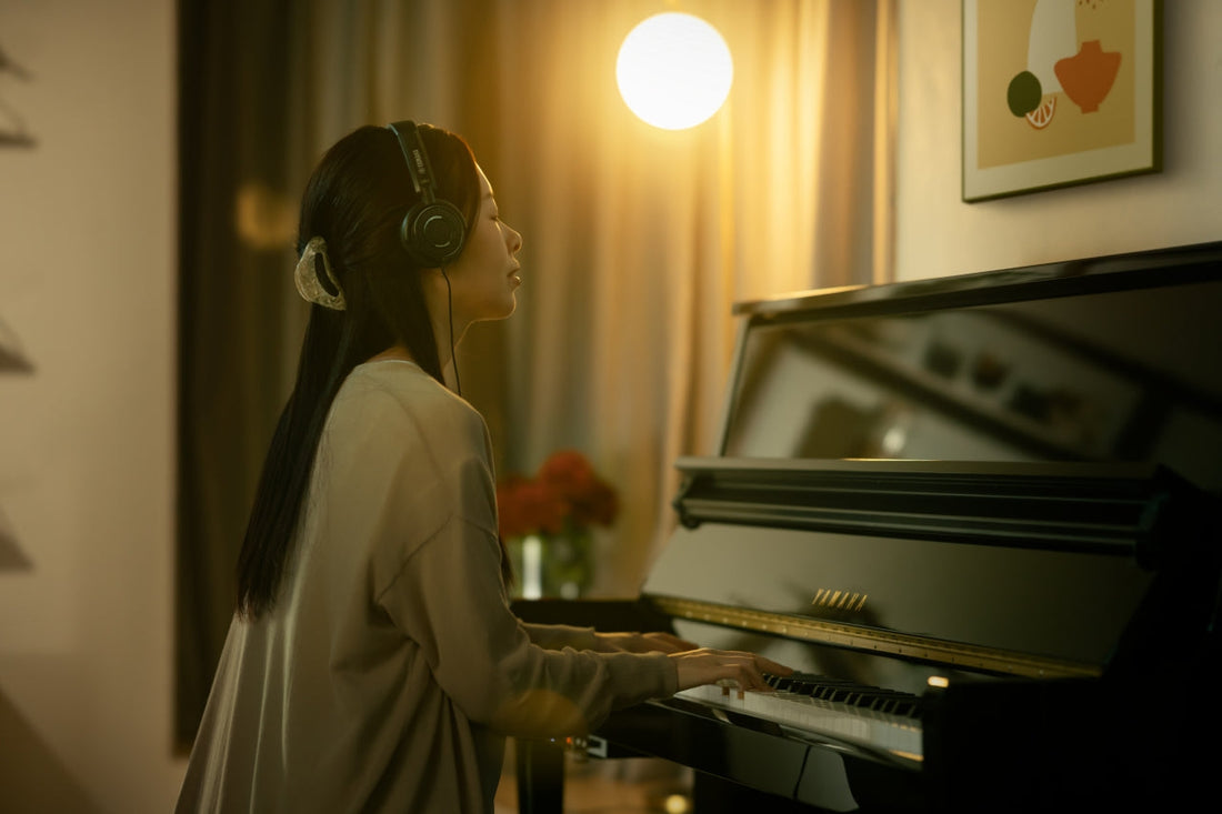 Iemand speelt 's avonds piano met een koptelefoon op