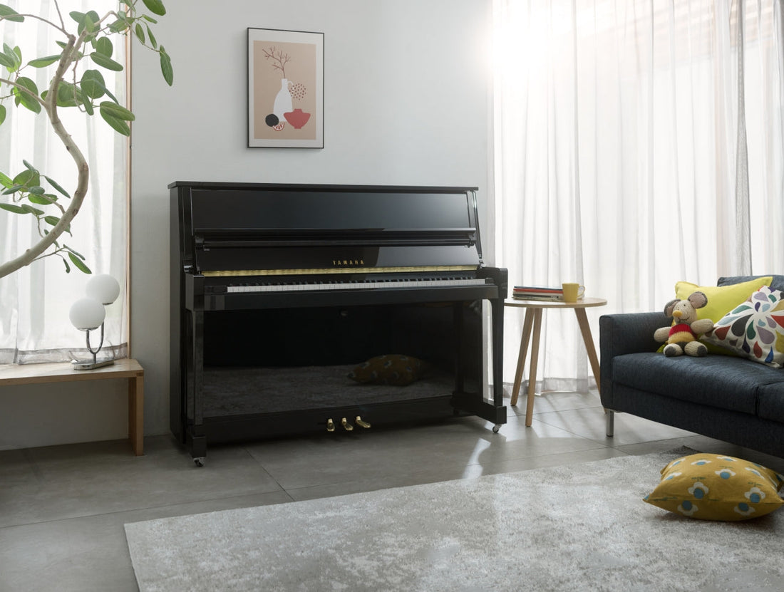 Staande piano in een woonkamer, met de wielen zichtbaar op de vloer