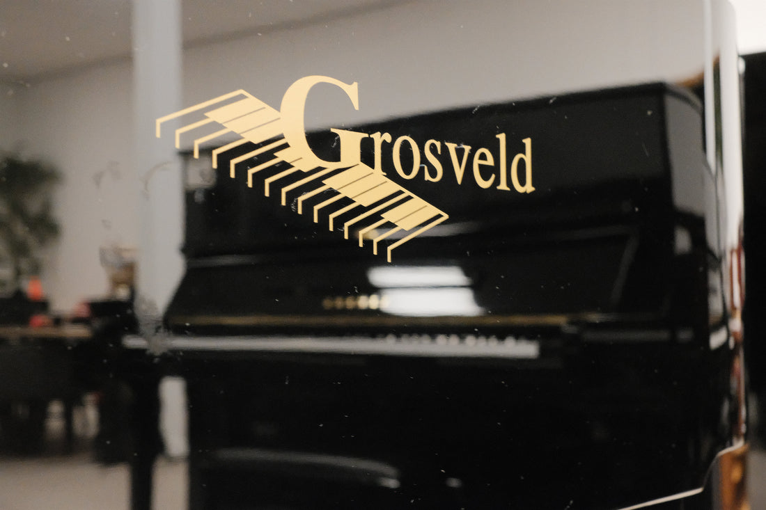 Zwarte piano met het Grosveld-logo in de showroom
