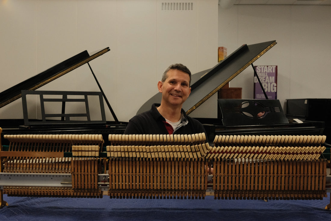 Pianotechnicus achter uitgenomen pianomechanieken in de werkplaats